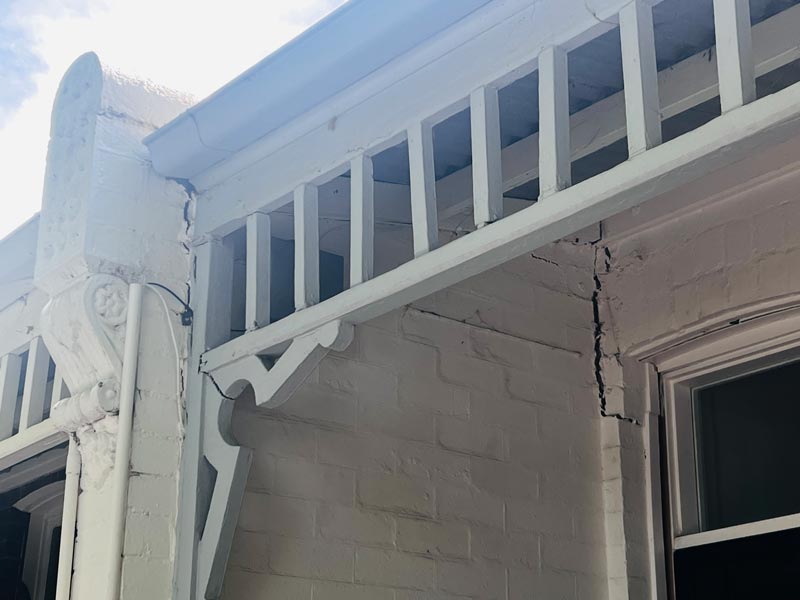Cracked and collapsed wall under porch.